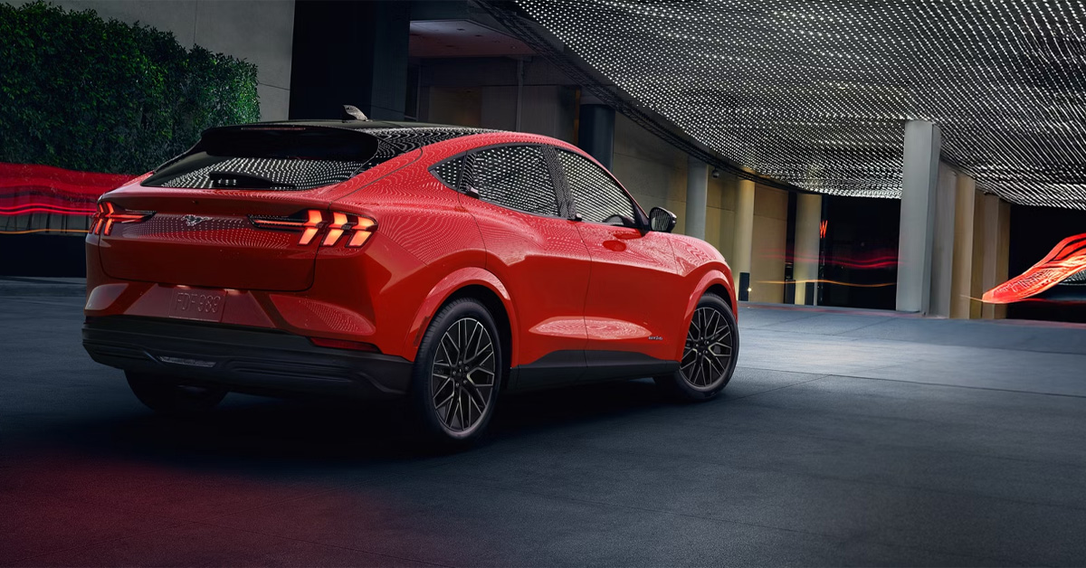 2026 Ford Mustang Mach-E exterior in red driving from the rear