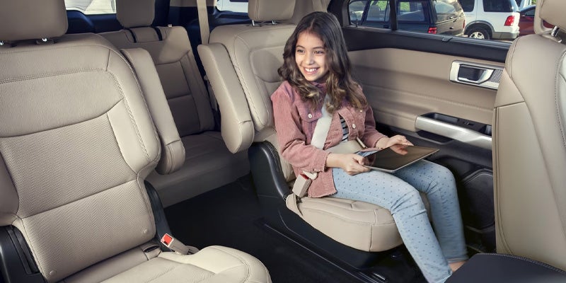 girl sitting in car holding an Ipad