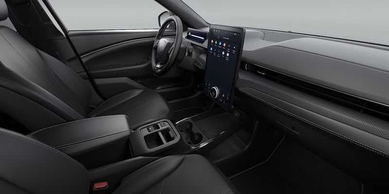 Modern car interior featuring black leather seats, a central touchscreen display